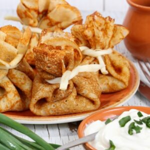 Блинные мешочки с начинкой подаются со сметаной