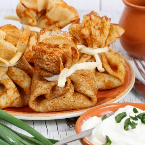 Блинные мешочки с начинкой подаются со сметаной